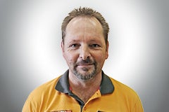 Porträt eines Mannes mit Bart und orangem Poloshirt