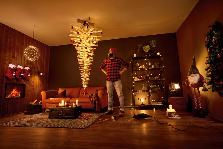 Gemütliches Wohnzimmer mit umgekehrtem Weihnachtsbaum, Kamin und Dekorationen für eine festliche Atmosphäre