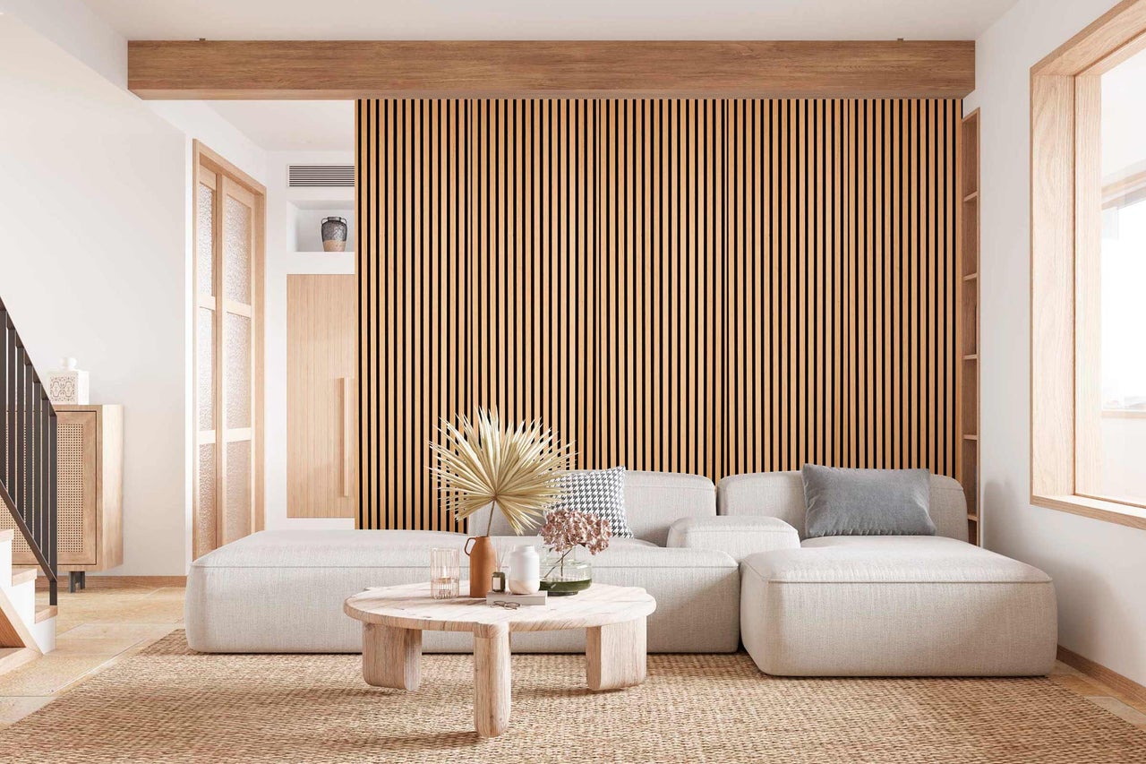 Wohnzimmer mit Akustikpaneelen an der Wand, Sofa und Holztisch
