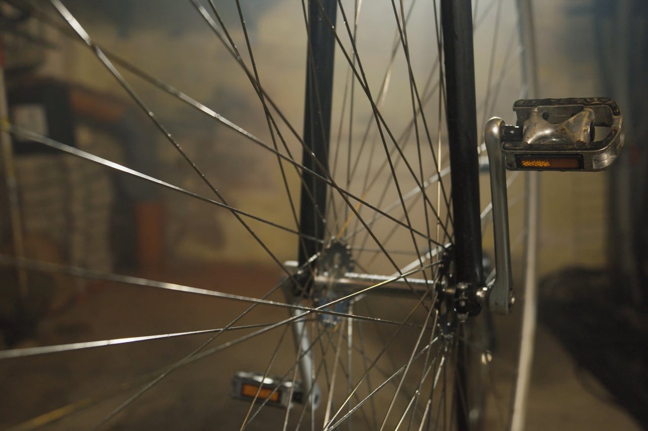 Nahaufnahme eines Fahrradreifens mit Speichen und Pedal