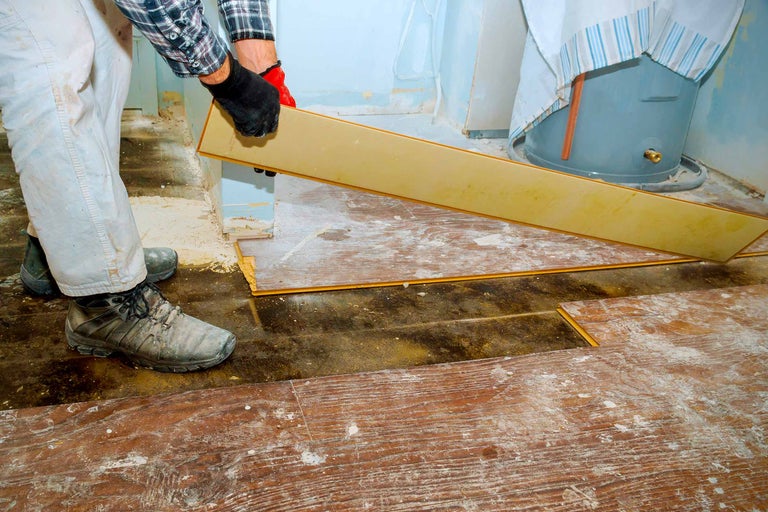 Handwerker verlegt Laminatboden in einem Raum.