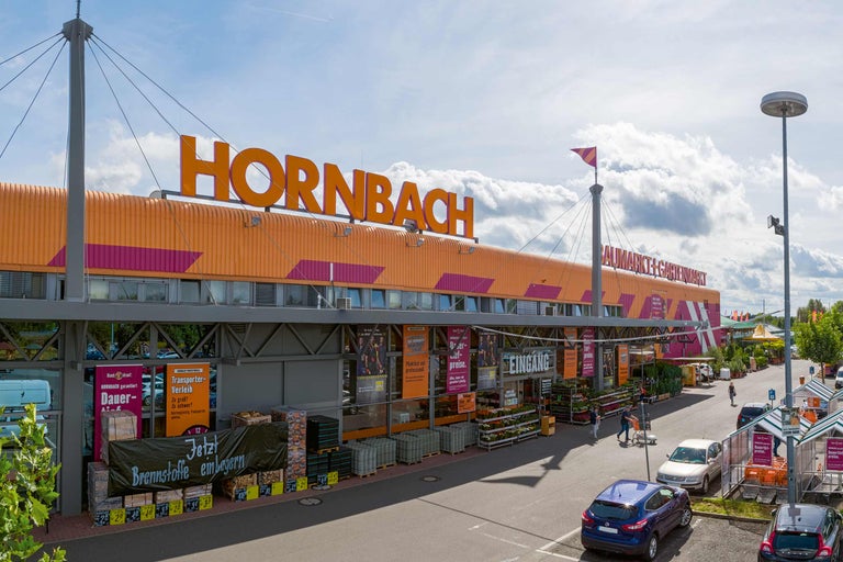 Außenansicht eines Hornbach Baumarktes mit Parkplatz und Warensortiment