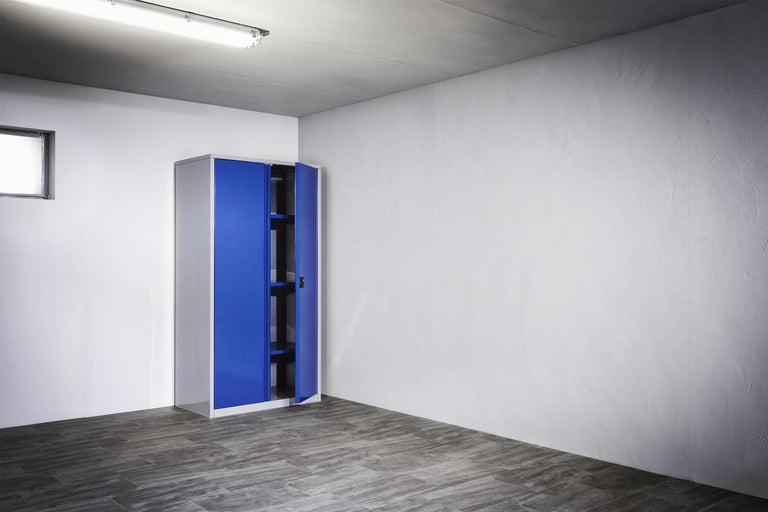 Stahlschrank mit Fachböden und Flügeltüren in einem hellen Raum