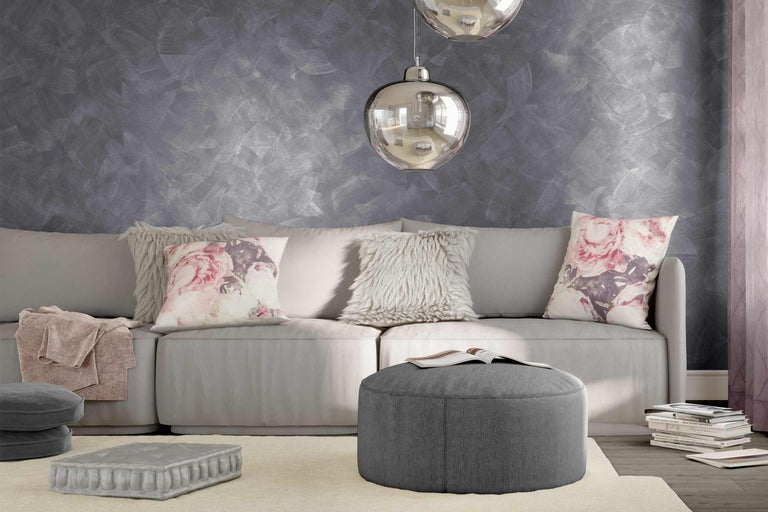 Helles Wohnzimmer mit Couch, Kissen, Hocker und Dekoration