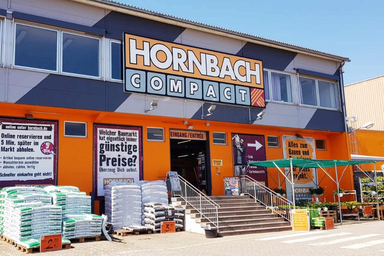 Außenansicht eines Hornbach Compact Baumarktes mit Eingangsbereich und Verkaufsflächen
