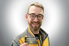 Ein lächelnder Mann hält eine Hornbach Kundenkarte in der Hand.