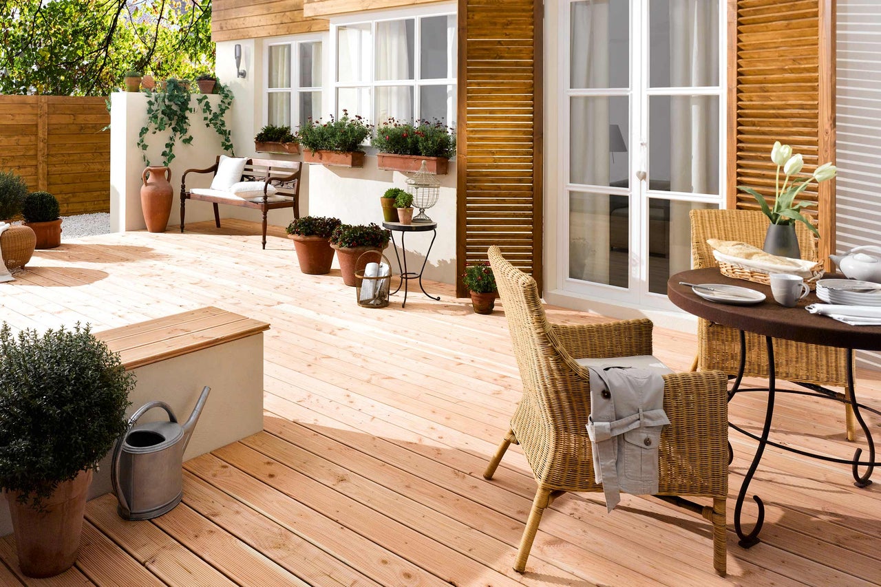 Terrasse mit Holzdielen, Gartenmöbeln und Bepflanzung