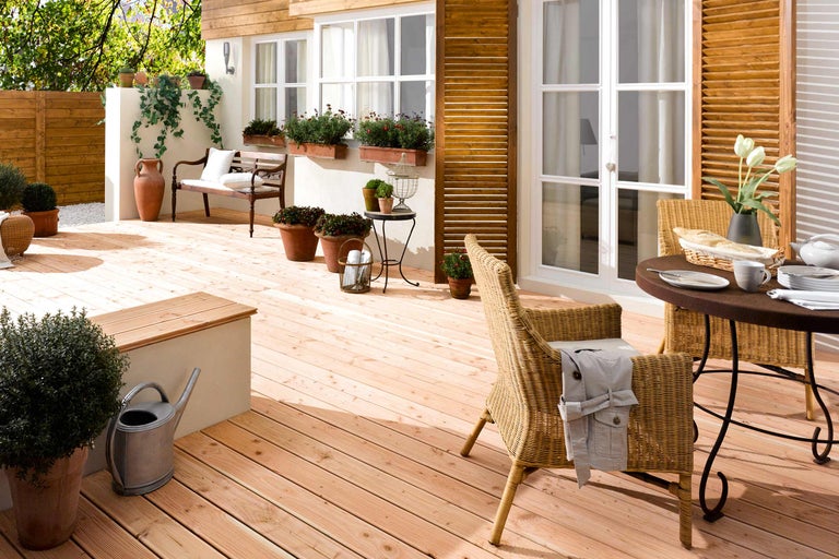 Terrasse mit Holzdielen, Gartenmöbeln und Bepflanzung