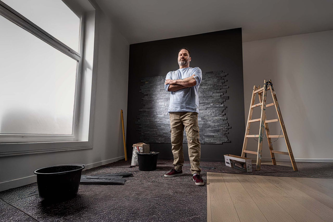 Raumrenovierung mit Steinwandverkleidung, Leiter, Eimer und Werkzeugen