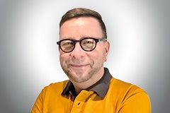 Porträt eines Mannes mit Brille und gelbem T-Shirt