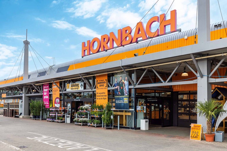 Außenansicht eines Hornbach Baumarktes mit Eingangsbereich und Pflanzenangeboten