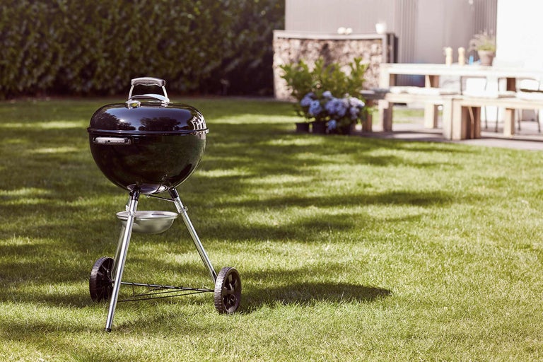 Kugelgrill auf einer Rasenfläche im Garten.