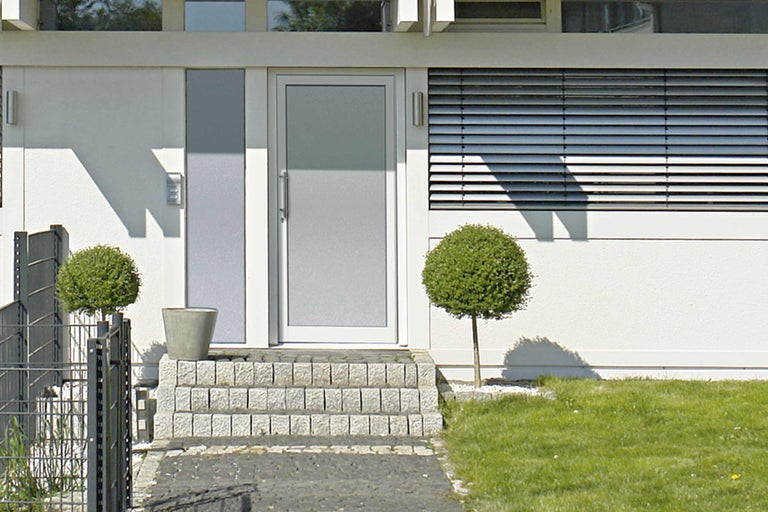 Modernes Haus mit Haustür, Steintreppe und Garten