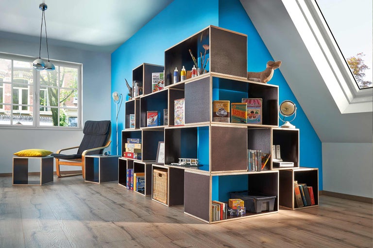 Wohnraum mit Regalsystem, Sessel und Dekoration für ein helles, modernes Ambiente