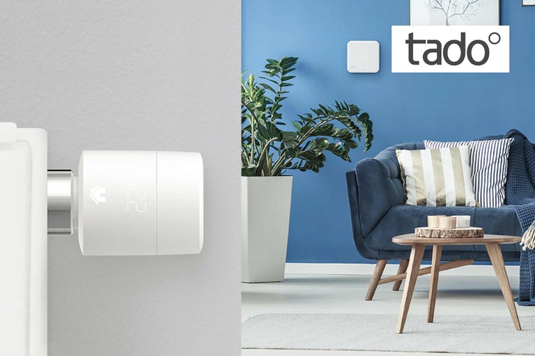 Raumszene mit Heizkörperthermostat, Zimmerpflanze, Couch und Tado Logo