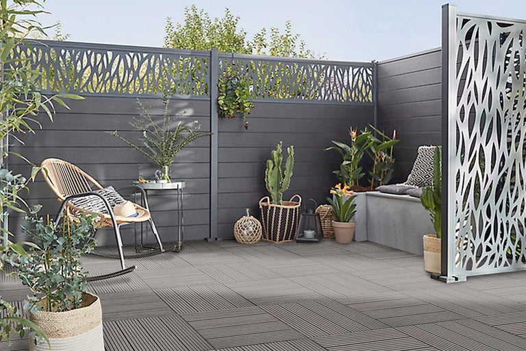 Gestalteter Außenbereich mit Sichtschutz, Gartenmöbeln und Bodenfliesen