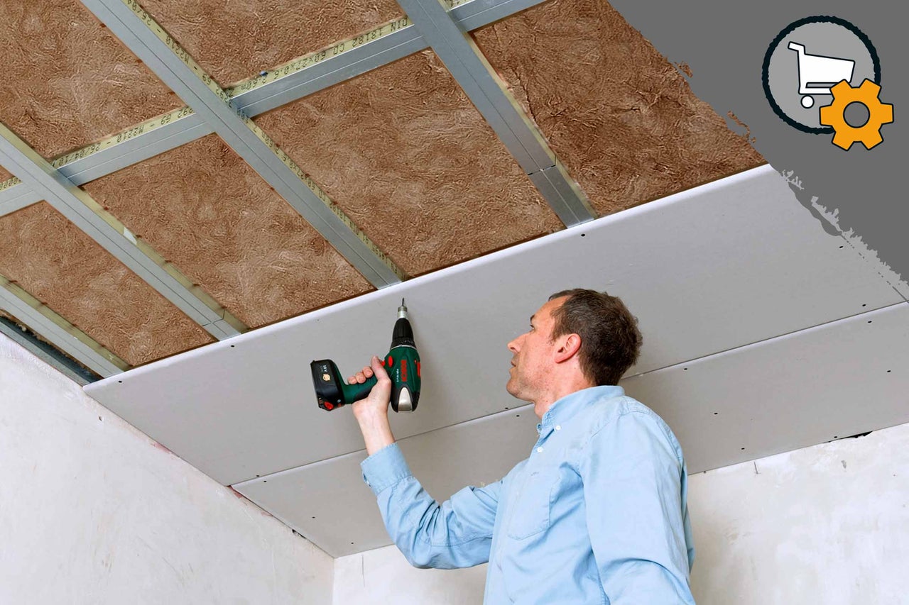 Mann montiert Gipskartondecke mit Akkuschrauber an Unterkonstruktion mit Dämmwolle