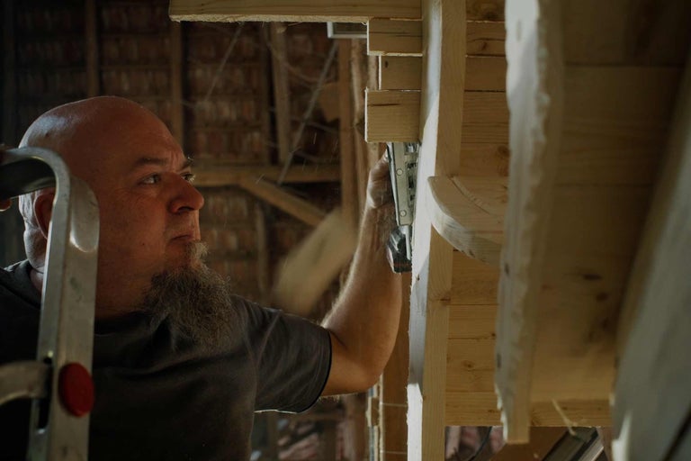 Handwerker befestigt Holzkonstruktion mit einem Klammergerät