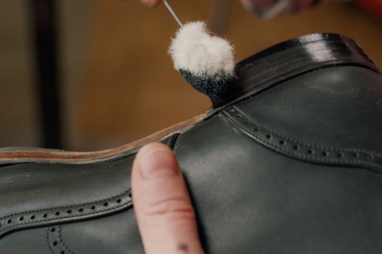 Detailaufnahme eines Lederschuhs, der mit einem Applikator gereinigt wird