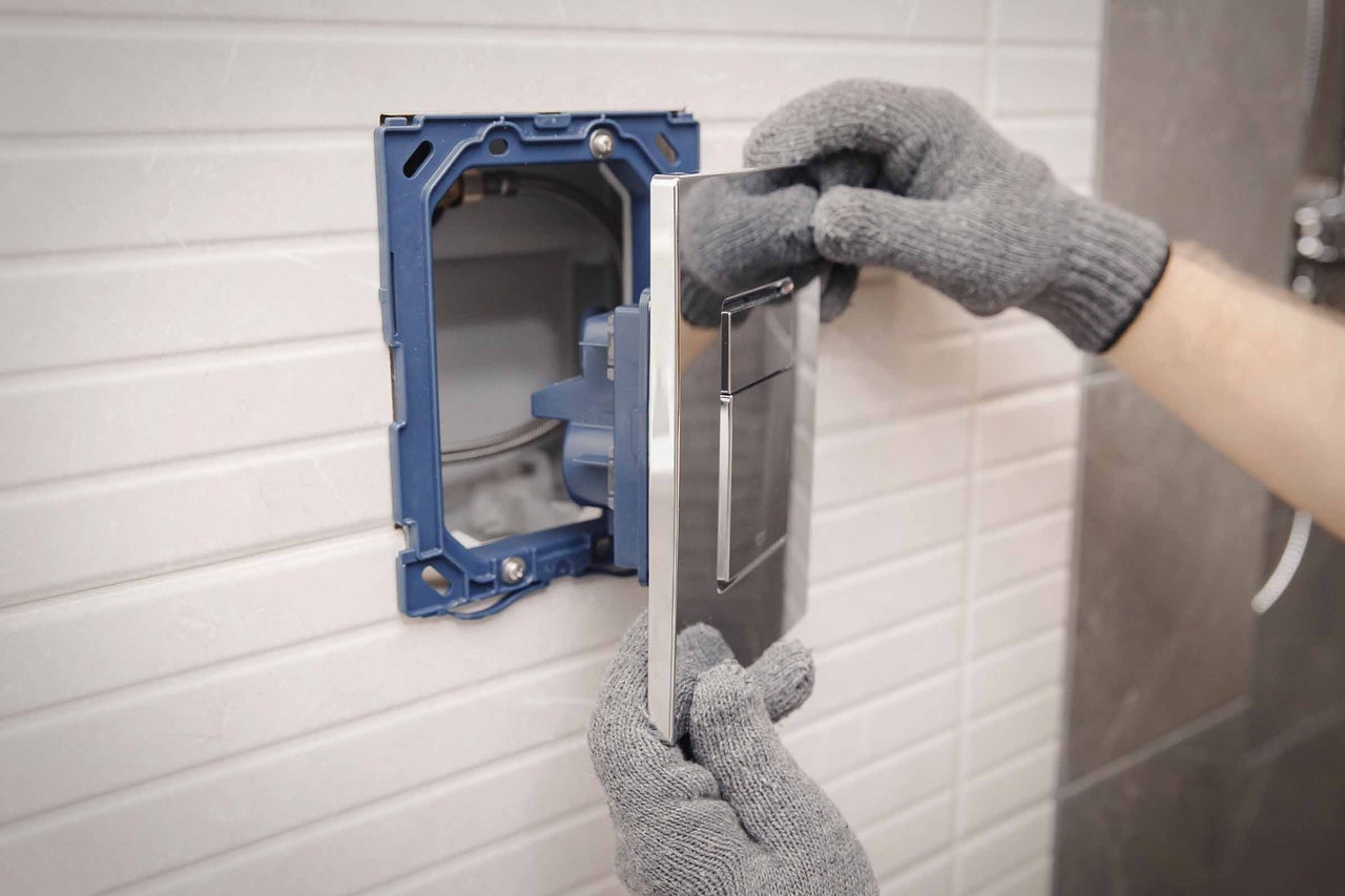 Installation einer Betätigungsplatte im Badezimmer.