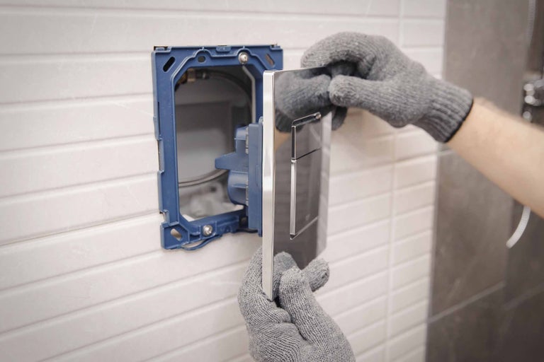 Installation einer Betätigungsplatte im Badezimmer.