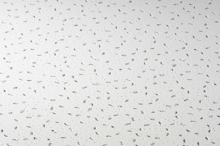 Nahaufnahme einer Akustikdecke mit Löchern zur Schallabsorption