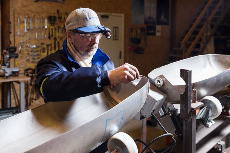 Ein Mann arbeitet in einer Werkstatt an einem Metallgegenstand