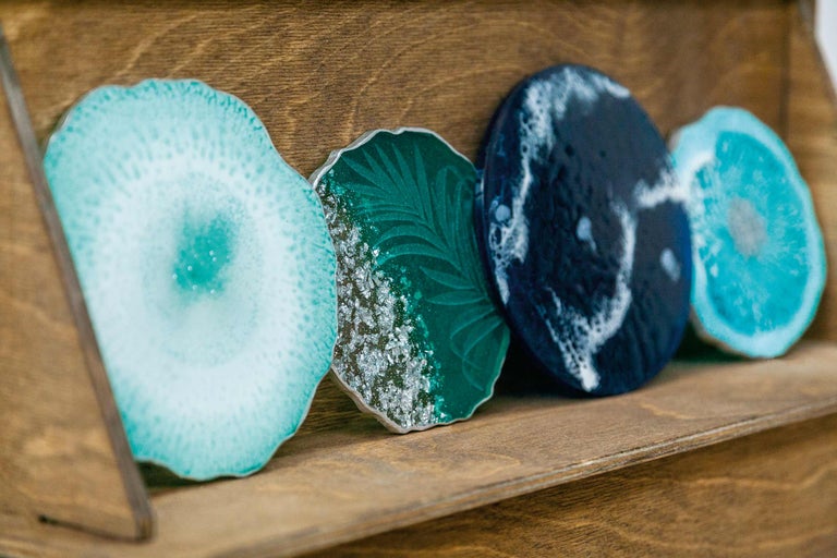 Dekorative Untersetzer aus Kunstharz auf einem Holzregal.