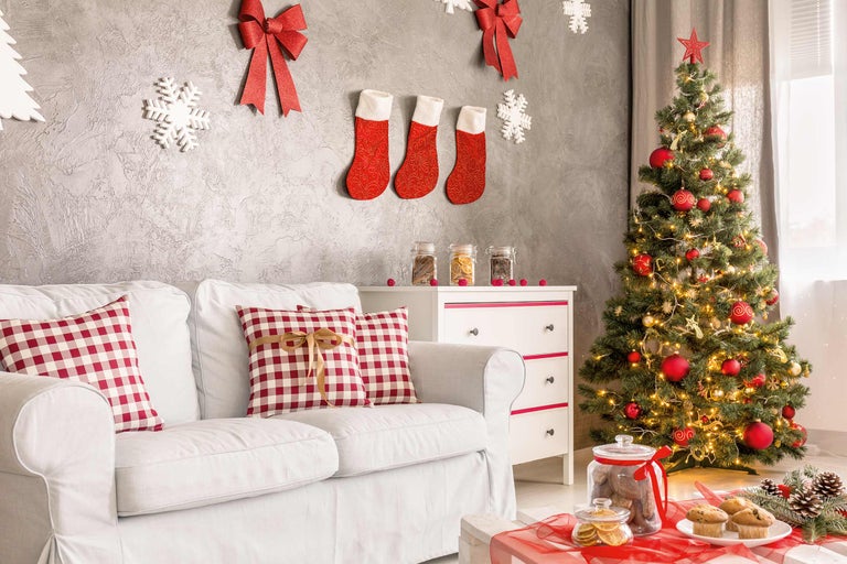 Weihnachtlich dekorierter Wohnraum mit Sofa, Weihnachtsbaum und Dekorationen