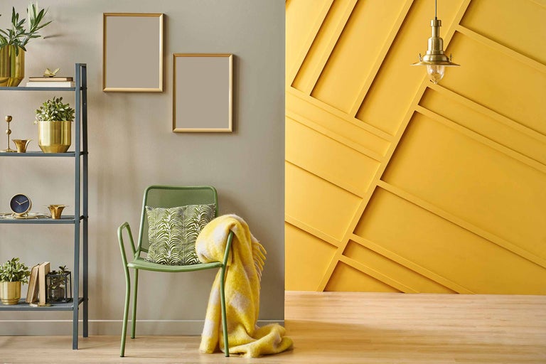 Dekoratives Wohnzimmer mit Regalen, Stuhl, Kissen, Decke und Wanddekor