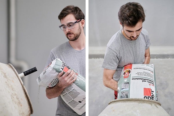 Mann schüttet Betonmischung in eine Betonmischmaschine