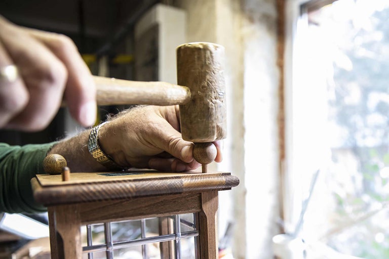 Mann montiert Holzprodukt mit Hammer