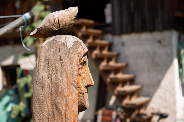 Holzskulptur eines Kopfes mit Vogel