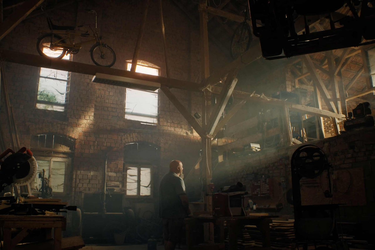 Werkstatt mit Werkzeugen, Holz und einem Mann