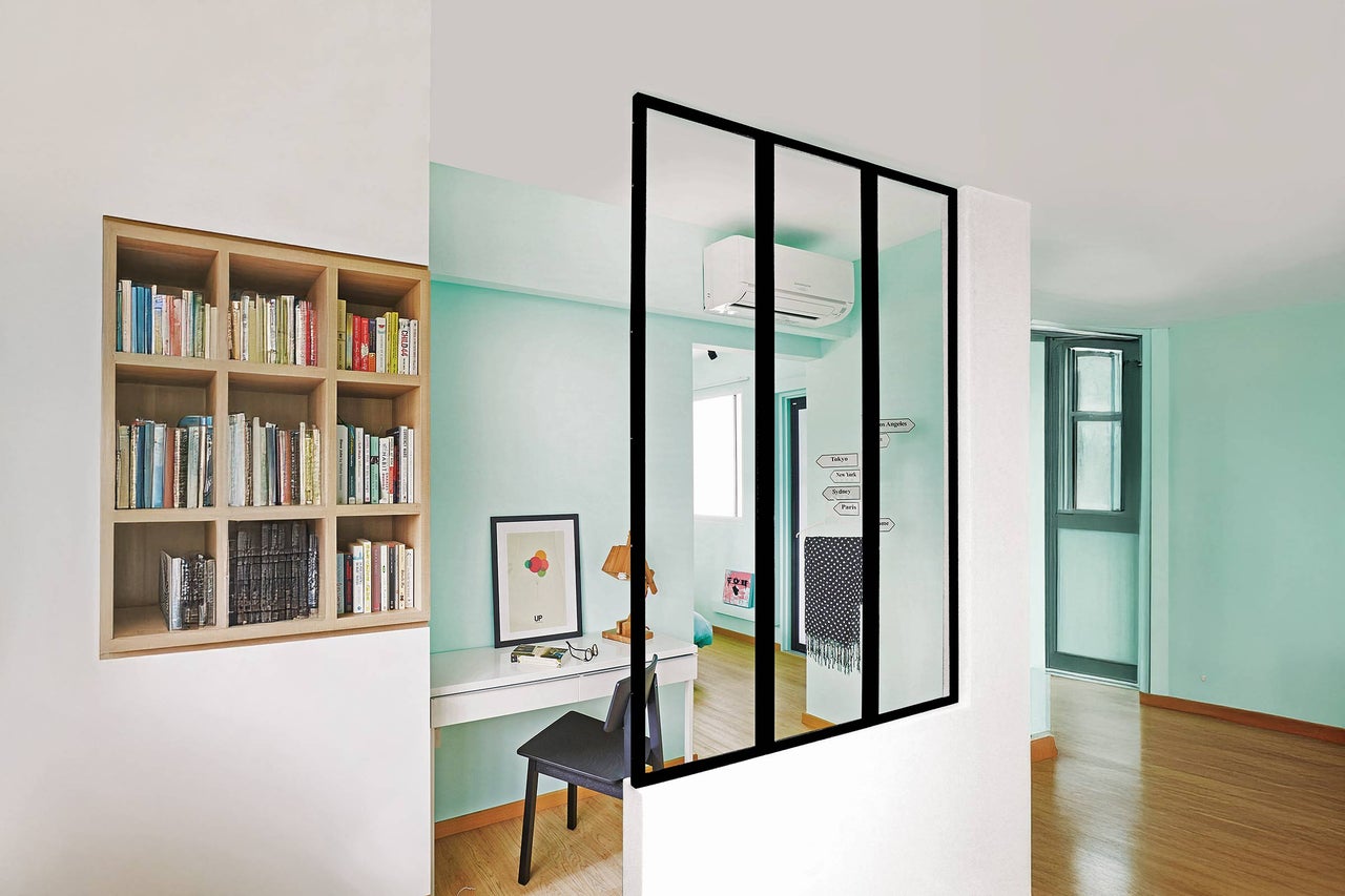 Helles Zimmer mit Bücherregal, Schreibtisch und Raumteiler mit Glas