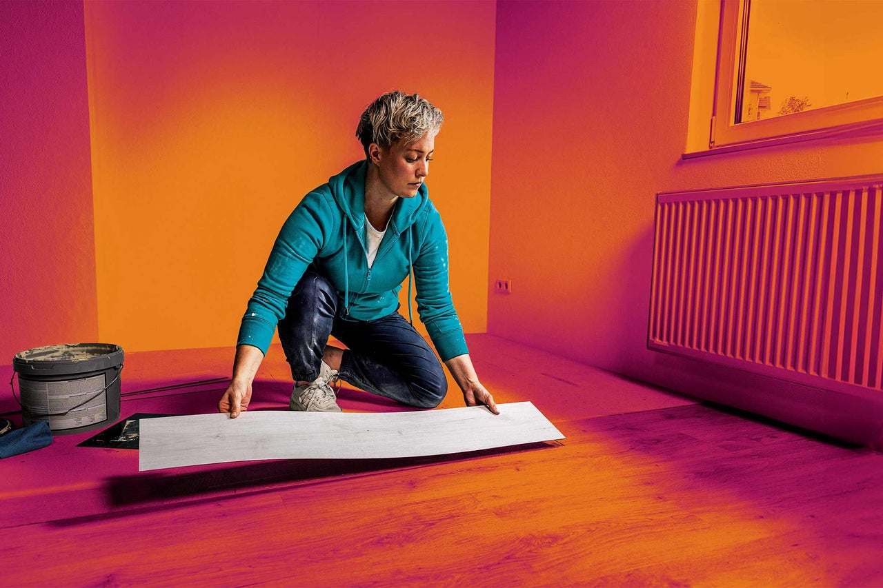Frau verlegt Designboden in einem Raum.