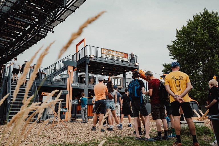 Hornbach Event mit Besuchern vor der Bar und der Bühne