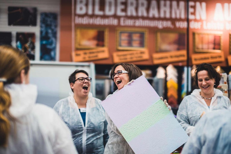 Menschen, die eine bemalte Platte mit verschiedenen Texturen betrachten