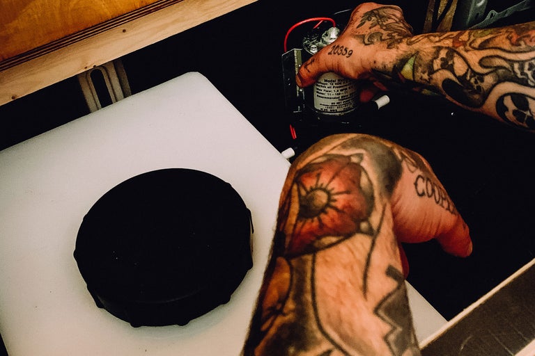 Wassertank mit Pumpe und tätowierten Händen