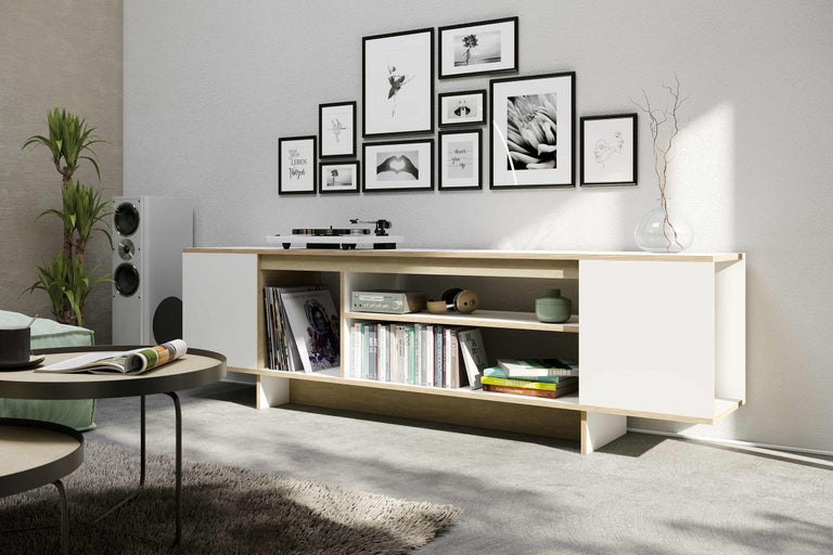 Wohnzimmer mit weißem Lowboard, Schallplattenspieler und dekorativen Bildern an der Wand
