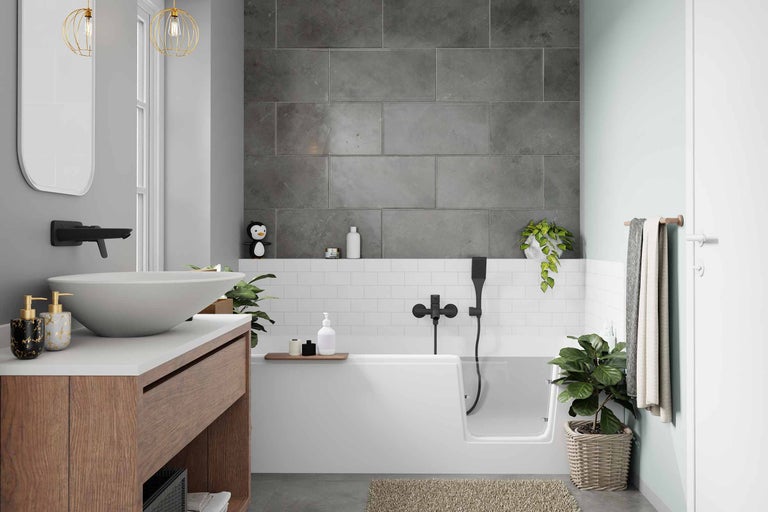 Modernes Badezimmer mit ebenerdiger Badewanne, Waschtisch mit Aufsatzwaschbecken und grauer Fliesenwand