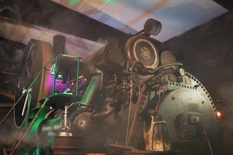 Detailaufnahme einer historischen stationären Dampfmaschine, die mechanische Präzision und industrielle Vergangenheit zeigt.