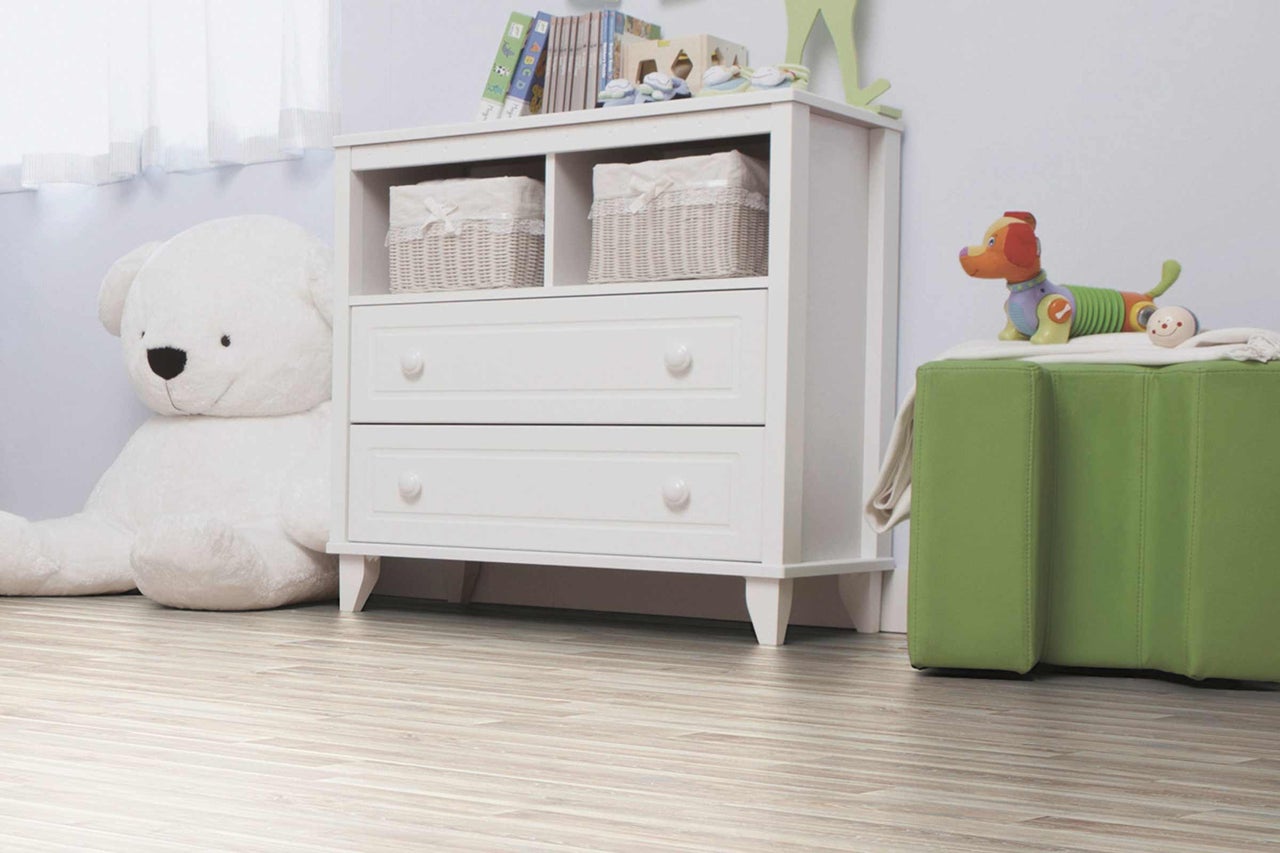 Kinderzimmer mit weißer Kommode, Spielzeug und Holzboden