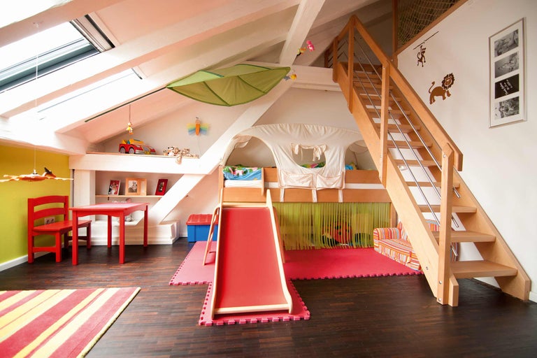 Kinderzimmer mit Hochbett, Rutsche, Treppe, Spieltisch und Stuhl.