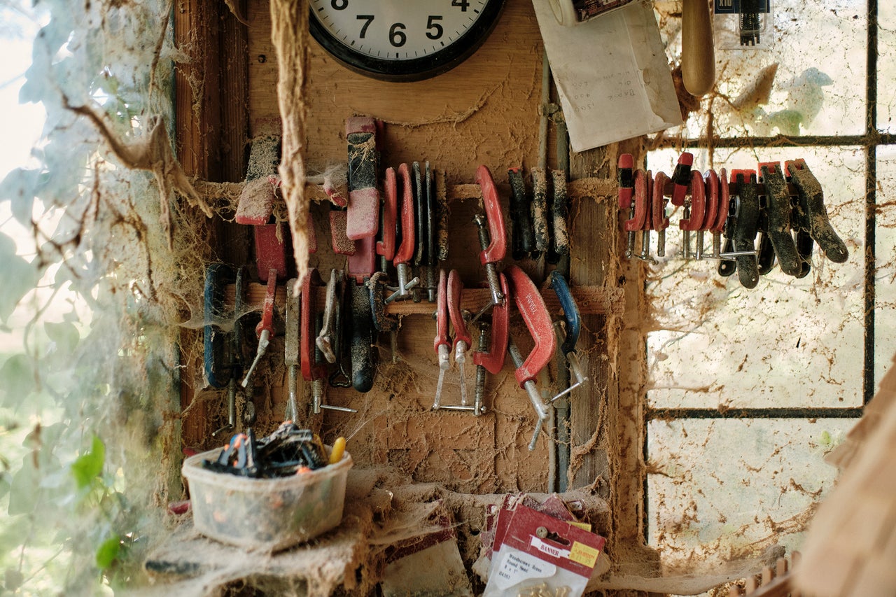 Werkstattwand mit Schraubzwingen, Uhr, Werkzeug und Schrauben