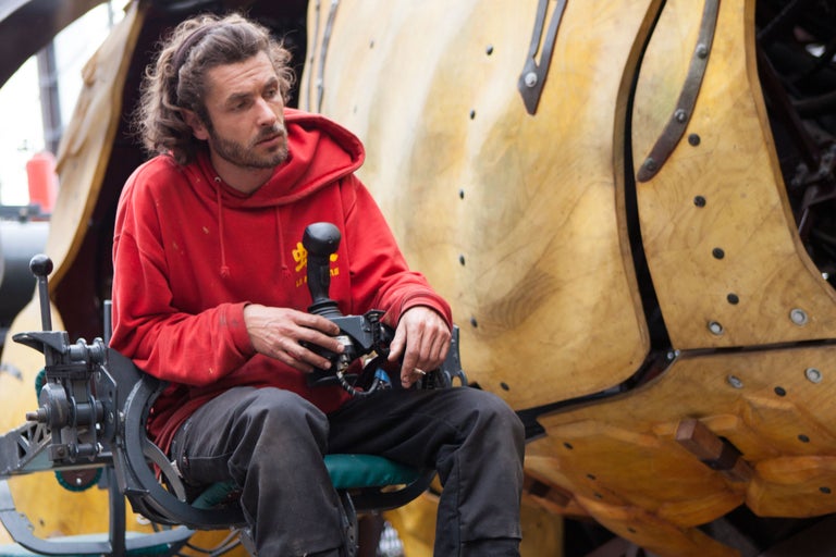 Mann in rotem Pullover steuert Maschine mit Joystick