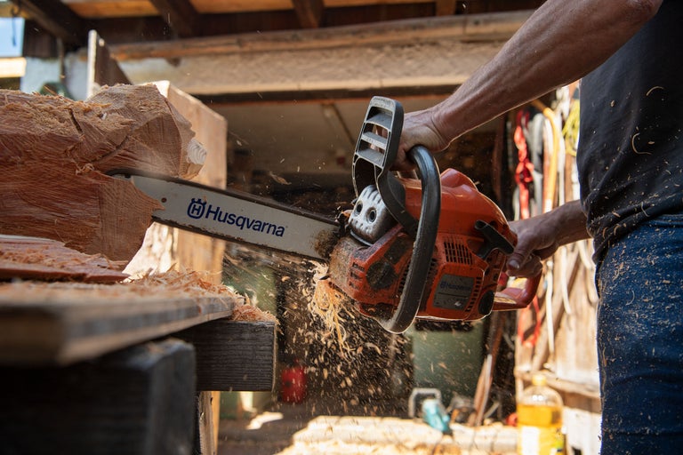 Eine Husqvarna Kettensäge schneidet Holz.