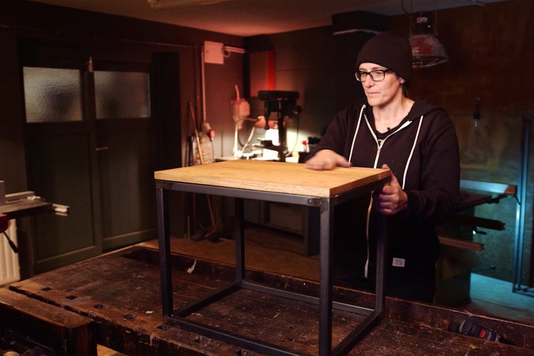 Quadratischer Beistelltisch mit Holzplatte und Metallgestell in Werkstatt