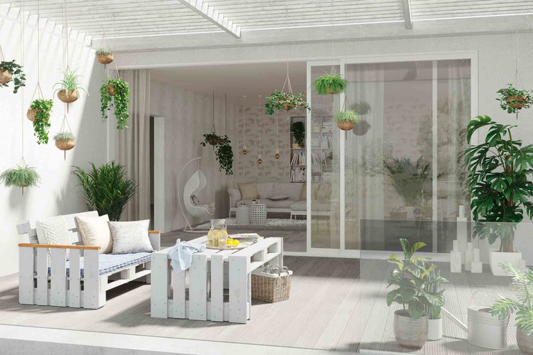 Terrasse mit Sitzgruppe, Tisch und hängenden Pflanzen in Pflanzgefäßen