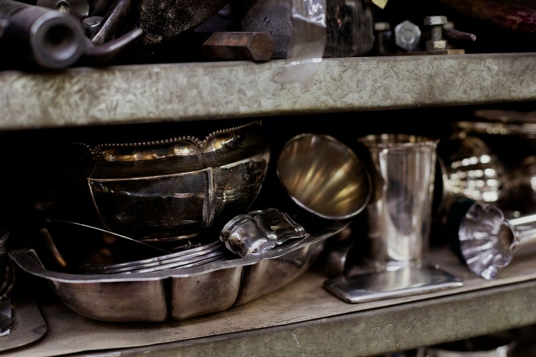 Regal mit Silberwaren wie Schalen, Besteck und Bechern